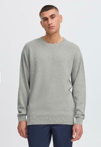 Hellgrauer Strickpullover mit Rundhalsausschnitt, langen Ärmeln, gerippten Bündchen und Saum, der ein strukturiertes Muster aufweist.