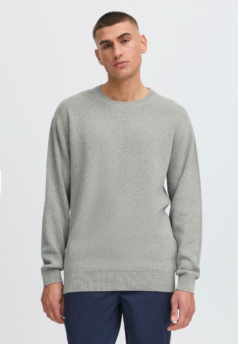 Hellgrauer Strickpullover mit Rundhalsausschnitt, langen Ärmeln, gerippten Bündchen und Saum, der ein strukturiertes Muster aufweist.