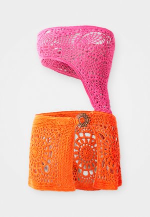 Top de crochet em rosa e laranja, com um design assimétrico, apresentando padrões florais e detalhes recortados. Feito de fio texturizado.