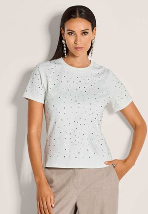 Witte t-shirt met korte mouwen, versierd met verspreide zwarte stippen. Gladde katoenstof met een klassieke ronde halslijn.