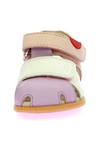 Sandalia de piel en tonos pastel: rosa claro, blanco y lavanda. Cuenta con correas ajustables de velcro, punta abierta y suela de goma.