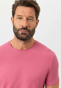 T-shirt met korte mouwen en een ronde hals in effen roze kleur, gemaakt van zachte stof met een gladde textuur en minimale stiksel details.