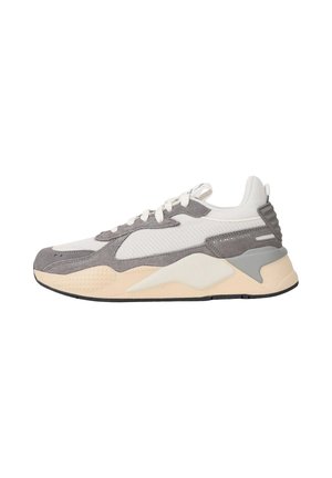 Sneaker low-top con mesh bianco, sovrapposizioni in camoscio grigio, suola imbottita beige, chiusura frontale con lacci e tallone testurizzato vista laterale su sfondo bianco.