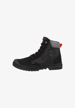 Bocanci până la gleznă din suede negru, cu panouri laterale sintetice, șireturi portocalii și un panou de călcâi gri contrastant. Prezintă un logo circular pe lateral.