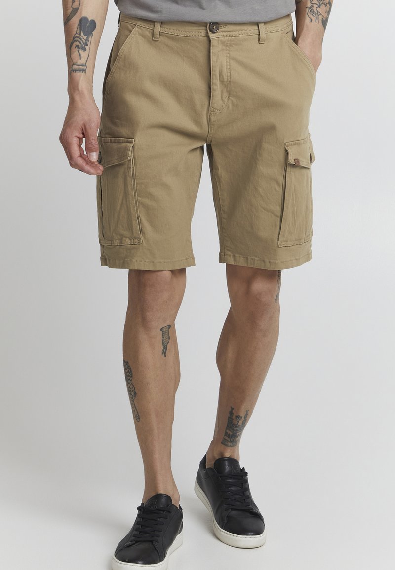 Shorts cargo kaki avec une coupe détendue, fabriqués en tissu coton durable. Comprend plusieurs poches et une fermeture à bouton à la taille.