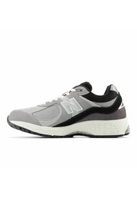 Baskets de sport gris et noir avec semelle blanche, panneaux en mesh et en daim, lacets et logo "N" sur le côté.