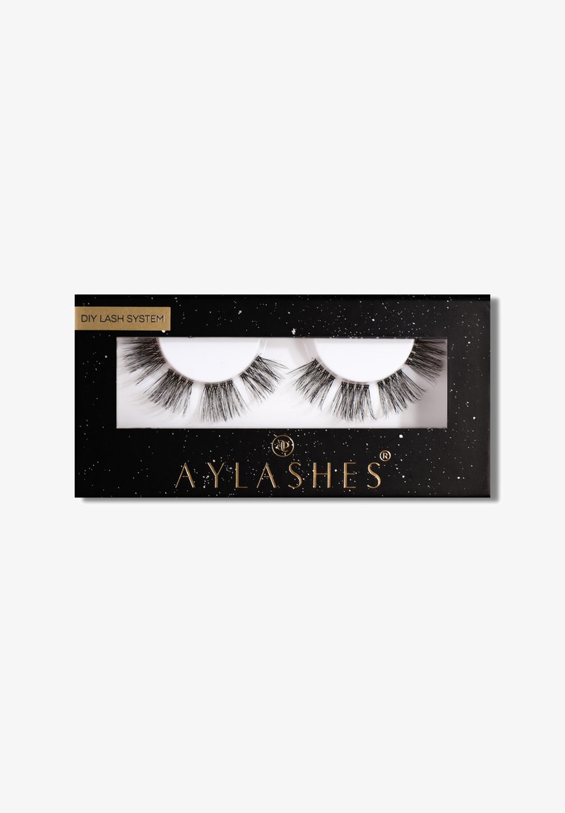 False eyelashes in a clear plastic holder within a black box, featuring a gold logo and white speckles on the surface.
