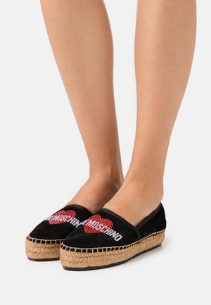 Espadrilles de ante negro con el logo "Moschino" en rojo y plata, diseño de corazón, suela de yute trenzado y estilo de slip-on plano.