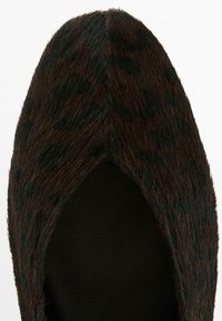 Leopard-print flat shoe with a black and brown textured finish. Designed with a pointed toe and soft fabric upper for comfort.
