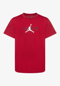 Czerwona bawełniana koszulka z krótkim rękawem z białym logo Jumpman i napisem "JORDAN" w kolorze czarnym, okrągły dekolt.