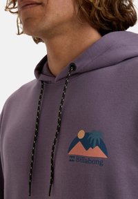 Purple hoodie featuring a front graphic of mountains, sun, and palm tree in blue and coral. Black drawstrings with yellow accents.