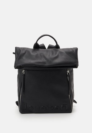 Mochila de cuero negro con solapa superior doblada, dos cremalleras frontales verticales y nombre de la marca en relieve en la parte inferior frontal.