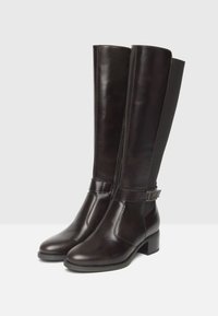 Bottes en cuir marron jusqu'au genou avec une finition lisse, dotées d'un petit talon carré et d'une sangle latérale avec des accents en métal.