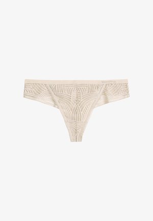 Lace thong in beige, featuring geometric patterns and intricate detailing. Soft fabric with a smooth waistband and minimal coverage design.