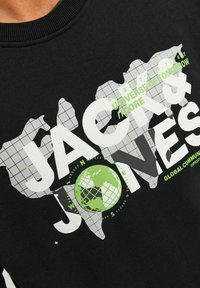 Sudadera negra con texto en blanco y verde en un diseño de globo y un contorno de mapa mundial, tela texturizada y cuello acanalado.