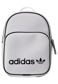 Bílý mini batoh Adidas s černým logem na přední kapse, černým lemováním a stříbrným zipem na bílém pozadí.