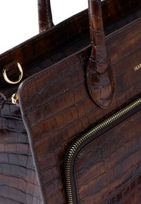 Sac à main en cuir marron foncé avec motif croco, doté de deux poignées et d'une fermeture éclair dorée sur la poche avant.