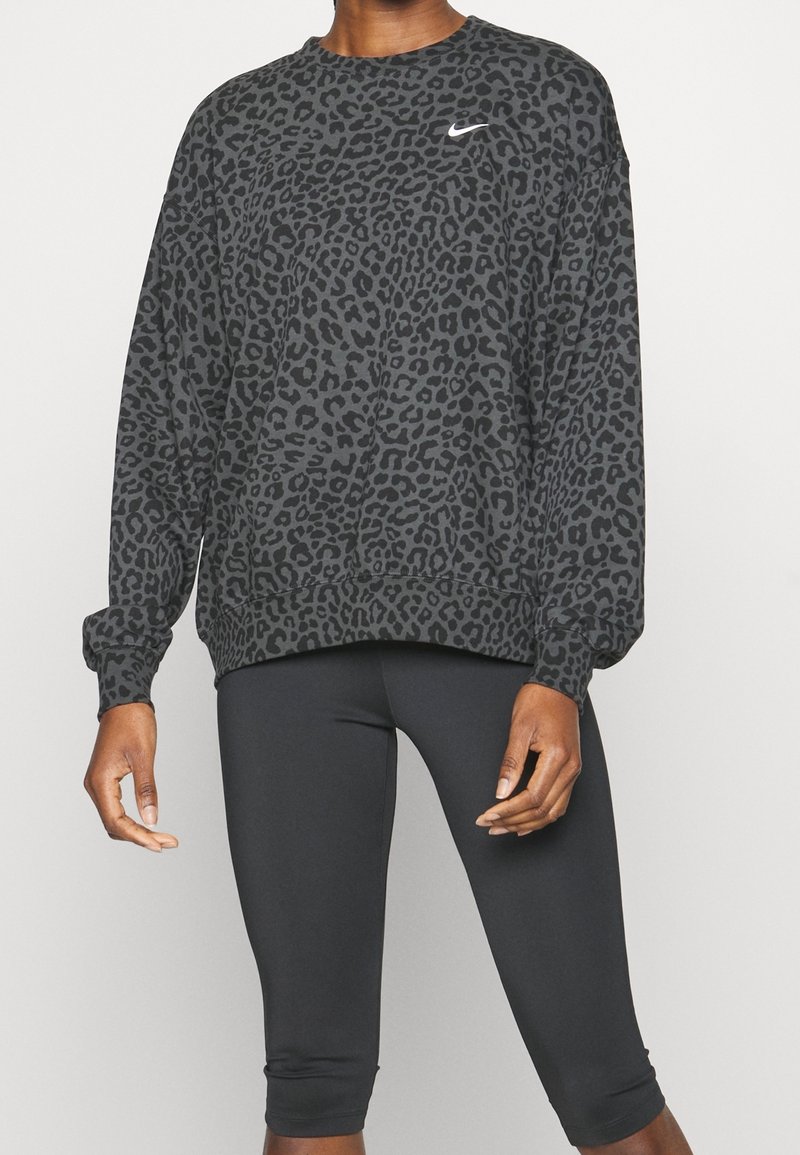 Sudadera negra de cuello redondo con un diseño de estampado de leopardo, que presenta mangas largas y un logo de Nike blanco en el pecho.