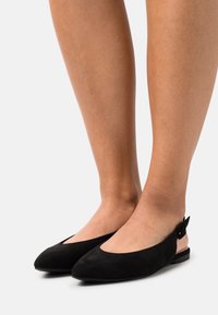 Czarne zamszowe baleriny slingback z wydłużonym noskiem i małym obcasem. Posiadają dodatkowy akcent w postaci klamry z boku, umożliwiający regulację dopasowania. Gładka struktura.