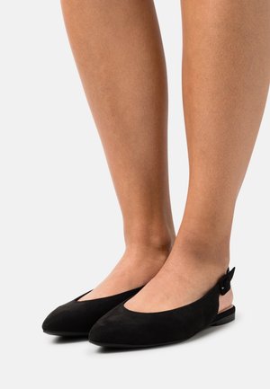 Ballerines en daim noir à dos ouvert avec un toe pointu et un petit talon. Présente un accent de boucle sur le côté pour un ajustement réglable. Texture lisse.