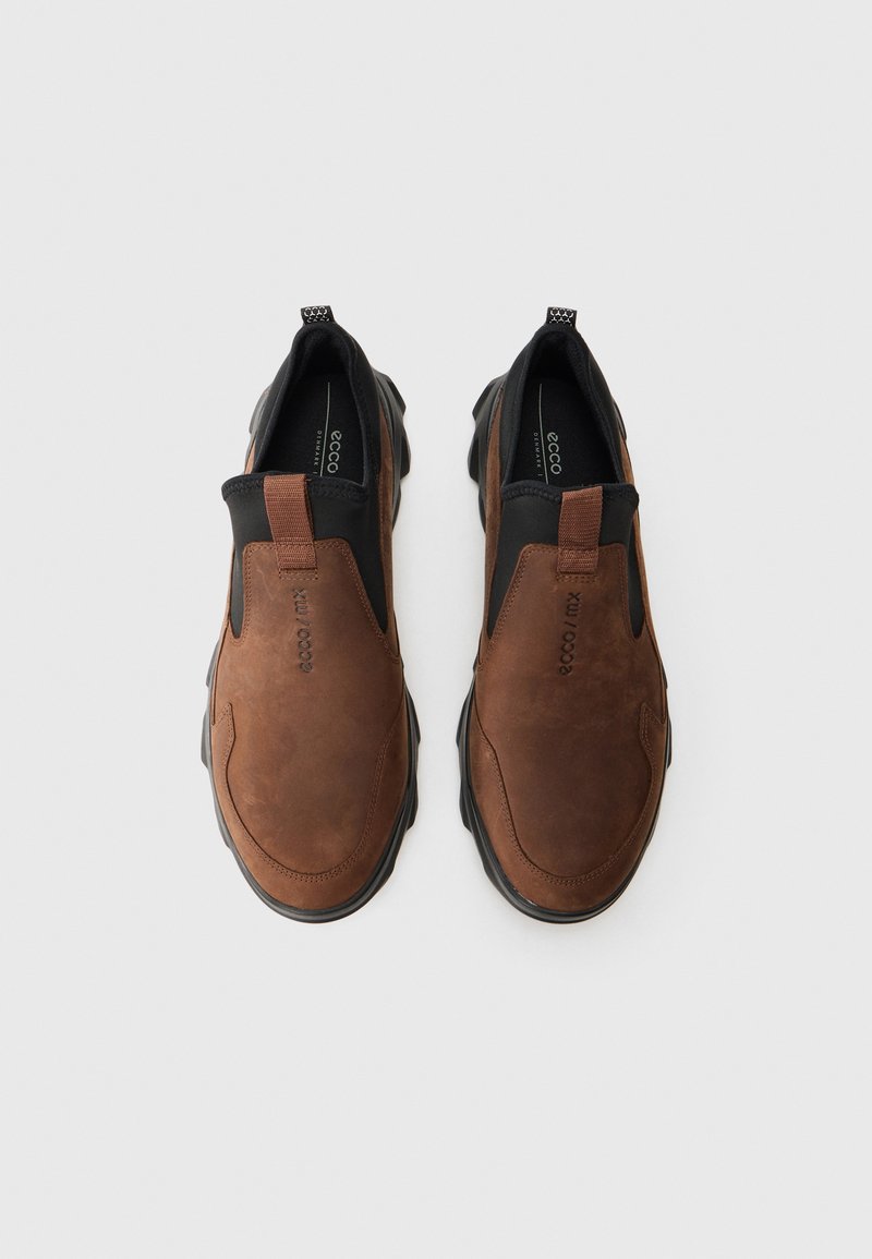 Braune Slipper aus glattem Leder mit einem schwarzen elastischen Einsatz und einer strukturierten Gummisohle für besseren Grip.