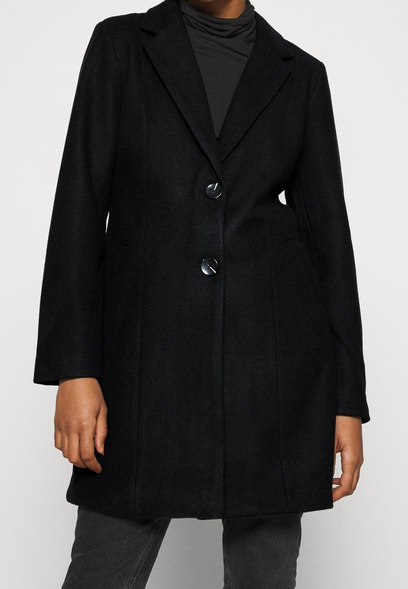 Manteau en mélange de laine noire avec un design ajusté, des revers crantés, deux boutons, des poches avant et une finition légèrement texturée.