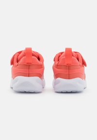 Baskets de sport corail avec une tige en textile lisse, un col rembourré et une semelle en caoutchouc blanche. Dotées d'une languette à l'arrière et d'une fermeture à velcro.