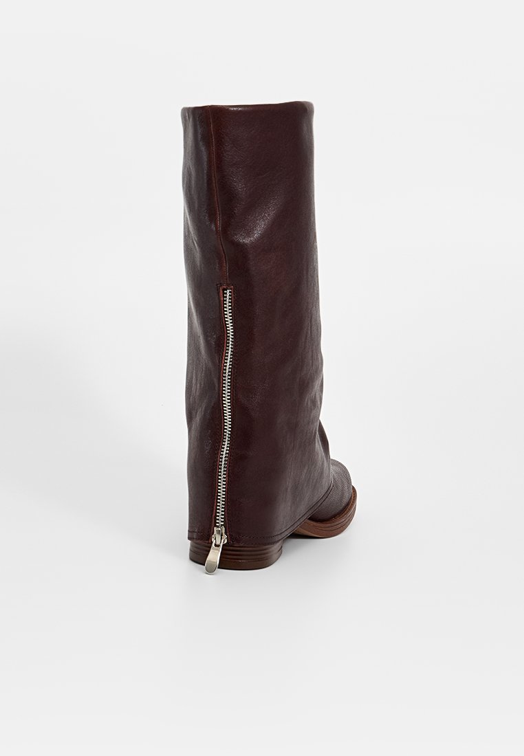 Botte en cuir marron, haute jusqu'au genou, avec une texture lisse, fermeture à glissière sur le côté et un petit talon empilé. Design simple et silhouette élégante.