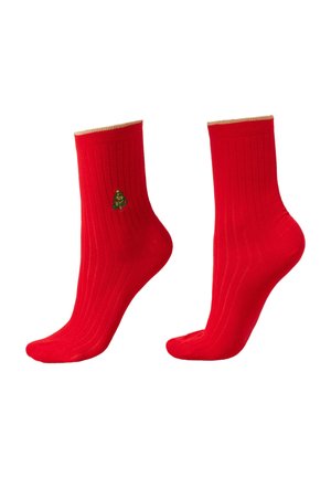 Chaussettes rouges côtelées avec un ourlet doré, présentant un petit design brodé d'un sapin de Noël vert sur le côté.