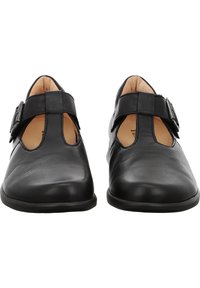 Scarpe in pelle nera con un design a T, dotate di un dettaglio con fibbia laterale e una superficie liscia. Punta arrotondata e interno imbottito.