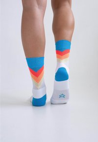 Mehrfarbige Crew-Socken mit blauen, orangefarbenen, gelben und weißen Streifen im Zickzackmuster; weicher Stoff; verstärkte Ferse und Zehen.