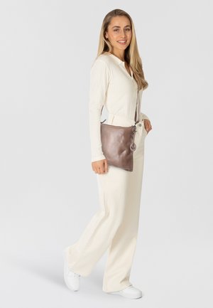 Borsa a tracolla in pelle marrone dal design minimalista, con chiusura a zip e un sottile pendente con logo.