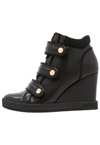 Svart läder wedge sneakers med tre justerbara remmar, guldfärgad hårdvara, rund tå och en texturerad gummisula.