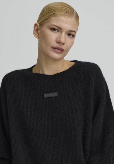 Fekete kötött pulóver bő szabással, széles nyakkivágással és texturált anyagból. Középen elöl fekete logófolttal.