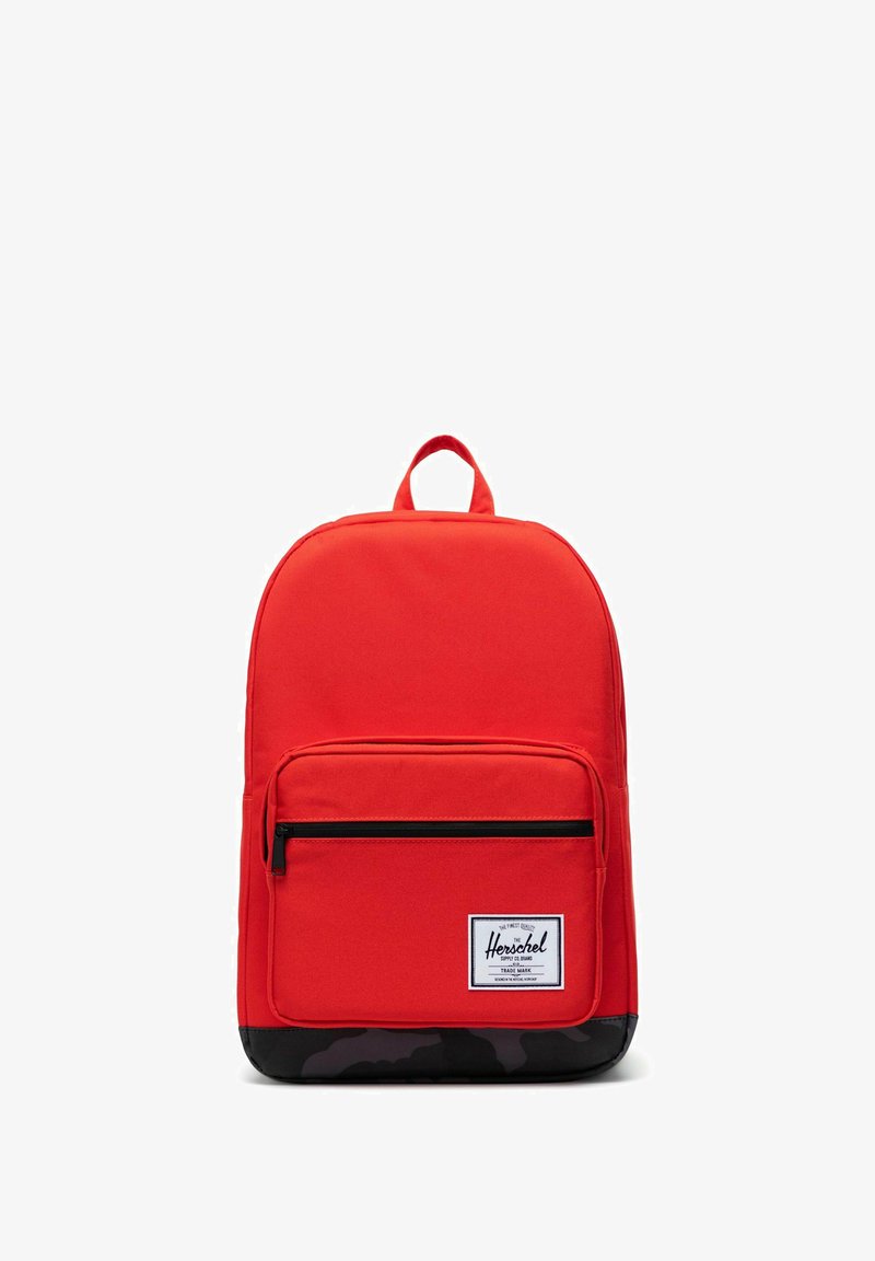 Sac à dos rouge en tissu résistant, doté d'un grand compartiment principal, d'une poche zippée frontale et d'un fond camouflage noir. Bretelles réglables et poignée.