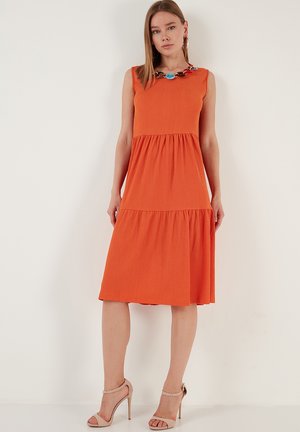 A knee-length orange dress made of textured fabric, featuring a fitted bodice and flared skirt. It has a colorful chain accent at the neckline.