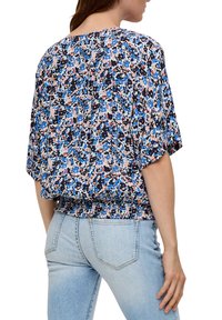 Bloemige blouse in blauw, roze en zwarte patronen, met een losse pasvorm, korte mouwen en een gerimpelde zoom. Zachte stofstructuur.