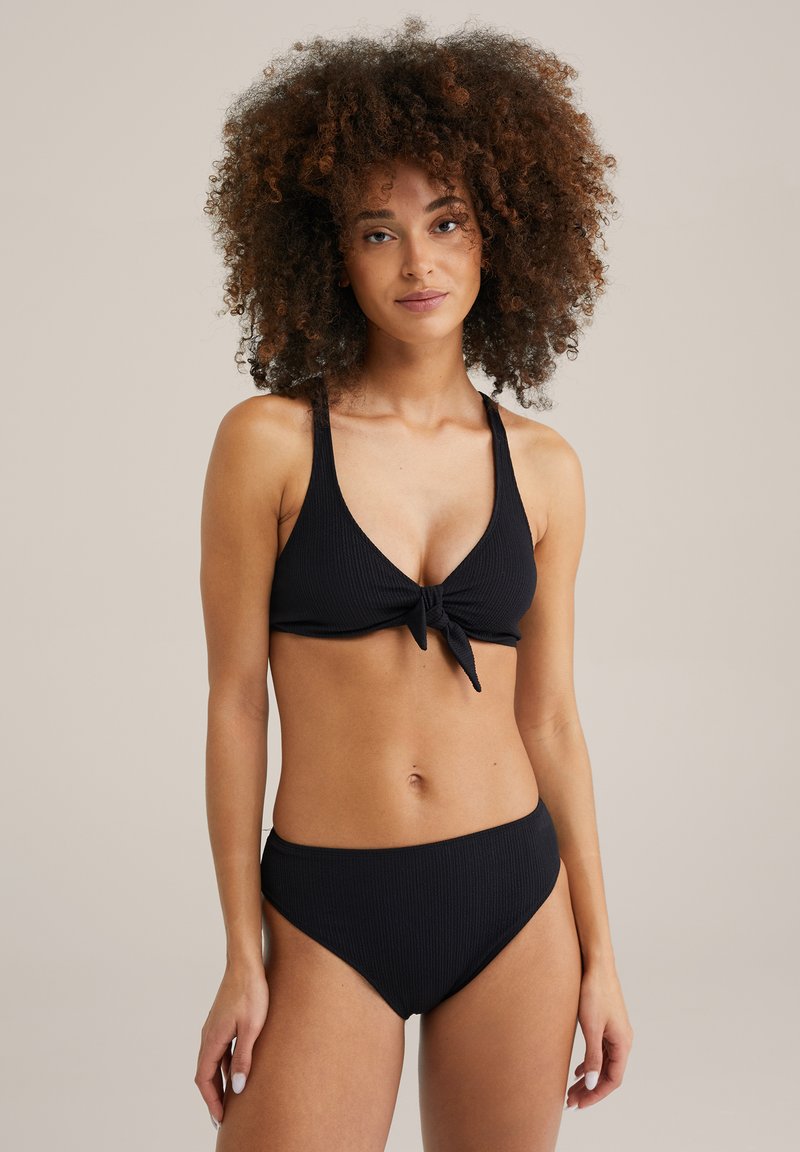 Črni rebrasti bikinij set, ki vključuje bralette s vezanjem spredaj z širšimi naramnicami in hlačkami visoko pasu. Gladka tekstura, minimalističen dizajn, brez vzorcev.