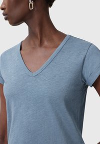 V-hals t-shirt i lyseblå, med korte ærmer og en blød tekstur. Stoffet ser glat ud med en afslappet pasform.