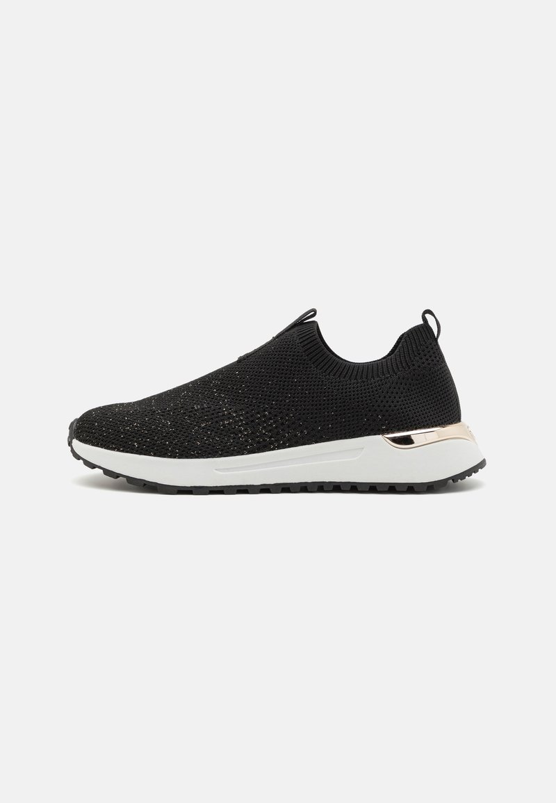 Black knit slip-on sneaker with a textured upper, white rubber sole, and a gold accent on the heel. Features a pull tab for easy wear.