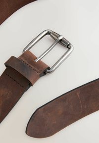 Brauner Leder Gürtel mit einer silbernen Metallschnalle, glatter Textur und sauber genähtem Rand. Das Ende des Gürtels ist verjüngt.