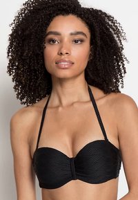 Črni bikini top bandeau z teksturiranim ribjim vzorcem, naramnicami okoli vratu in pritiklinom središču. Gladek material z oblikovanjem.