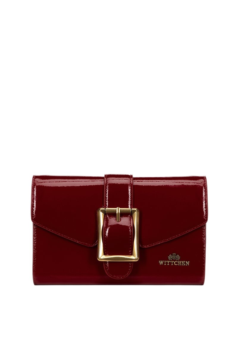 Červená peněženka z lakované kůže se zlatým detailem na přezce. Má klapkovou sponu a embosované logo na přední straně. Hladký, lesklý povrch.