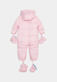 Różowy, puchowy kombinezon zimowy z kapturem, z pikowanymi sekcjami, przymocowanymi rękawiczkami i bucikami podszytymi jasnoniebieską tkaniną.