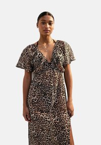 Maxi-jurk met luipaardprint, korte vlinder mouwen, diepe V-hals en een geplooide taille. Gemaakt van een lichtgewicht stof met een zachte textuur.