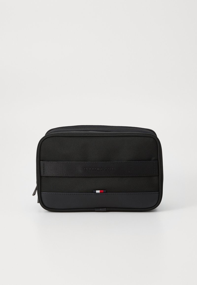 Black rectangular cosmetic bag made of durable fabric. Features a smooth front panel, logo, and a colored accent at the bottom. Zipper closure.