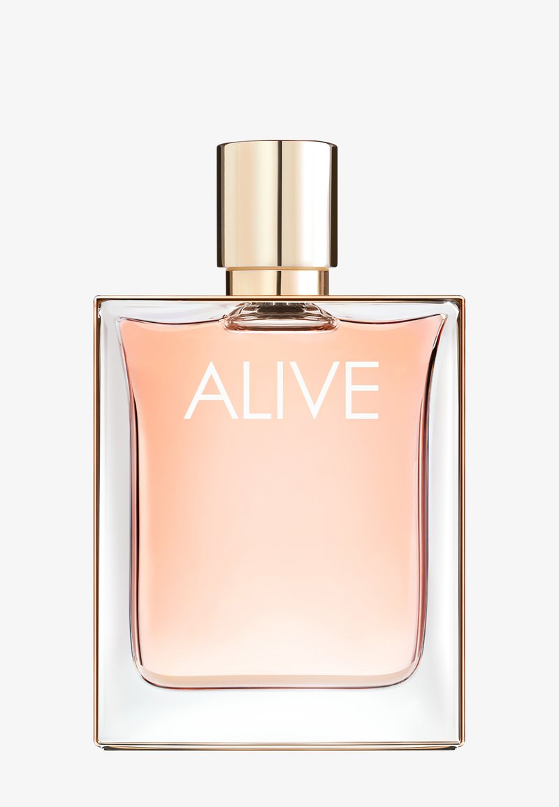 Prostokątna szklana butelka perfum z jasnoróżowym płynem, złotą zakrętką i napisem "ALIVE" z przodu.