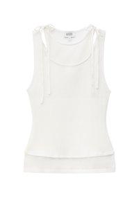 Débardeur blanc sans manches avec liens aux épaules et encolure ronde, en tissu léger.