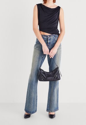 Černý bezramínkový top s volným designem, světle modré rifle s vysokým pasem, černá kabelka s klopnou a černé špičaté podpatky.