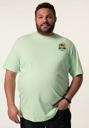Camiseta de manga corta en verde menta con un bolsillo que presenta un bordado de una palmera y un atardecer. Fabricada con un tejido suave y transpirable.